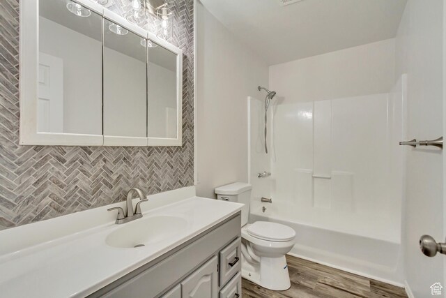 241 E Utah Ave, Tooele, UT 84074 - bathroom with backsplash, toilet, shower / bath combination, wood finished floors, and vanity