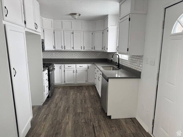 241 E Utah Ave, Tooele, UT 84074 - kitchen with dark countertops, dark wood-style flooring, stainless steel appliances, and a sink