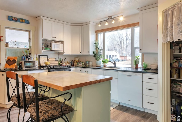 700 S 800 E, Springville, UT 84663 - kitchen featuring butcher block countertops, a breakfast bar area, a kitchen island, white appliances, and white cabinets