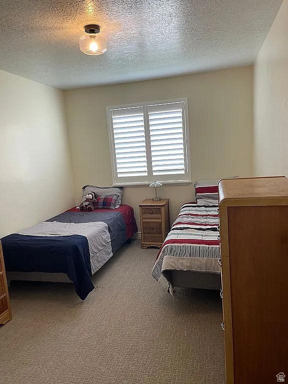 carpeted bedroom with a textured ceiling