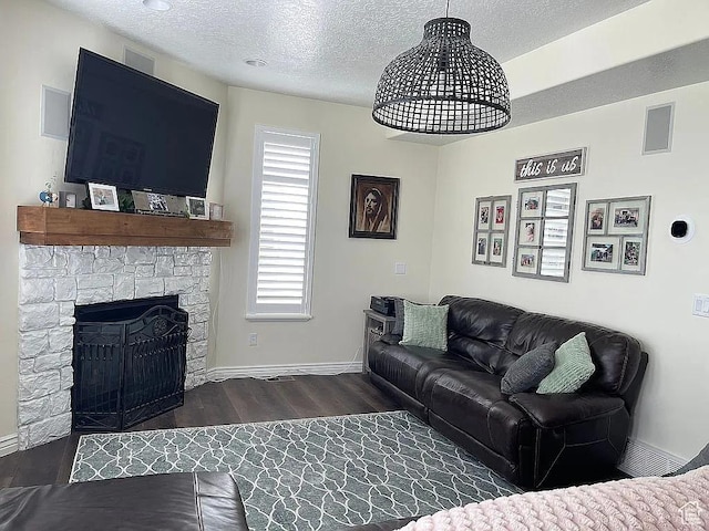 living room featuring dark hardwood / wood-style floors, a fireplace, and a textured ceiling