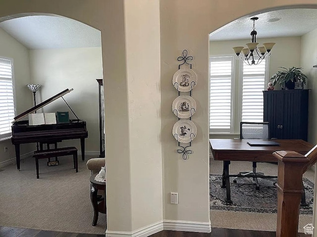 office with dark carpet, a wealth of natural light, a textured ceiling, and a chandelier