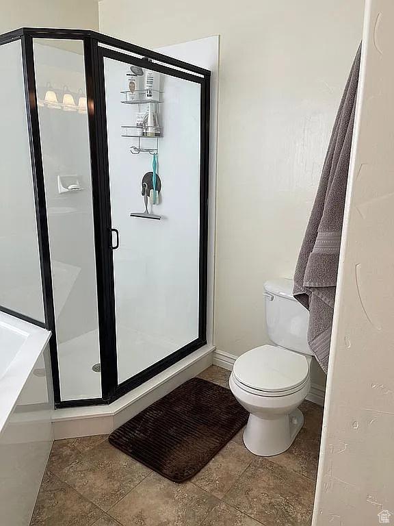 bathroom with an enclosed shower and toilet