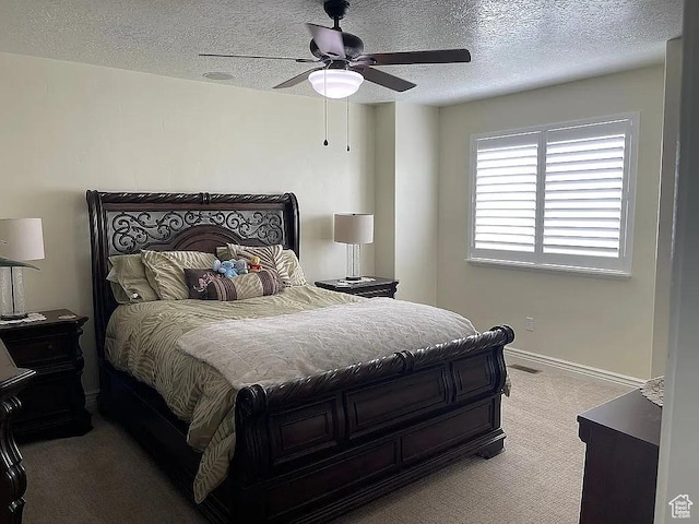 carpeted bedroom with ceiling fan and a textured ceiling