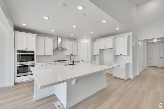 6184 W Teton Ranch Dr S Unit 304, Herriman, UT 84096 - kitchen with wall chimney exhaust hood, a sink, double oven, decorative backsplash, and a large island