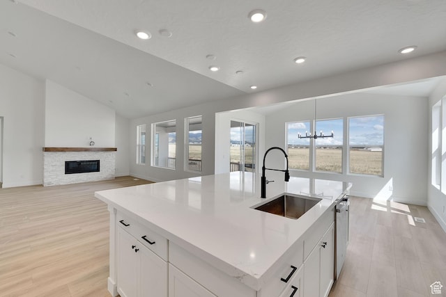 6184 W Teton Ranch Dr S Unit 304, Herriman, UT 84096 - kitchen featuring a sink, light wood-style flooring, a fireplace, white cabinetry, and recessed lighting