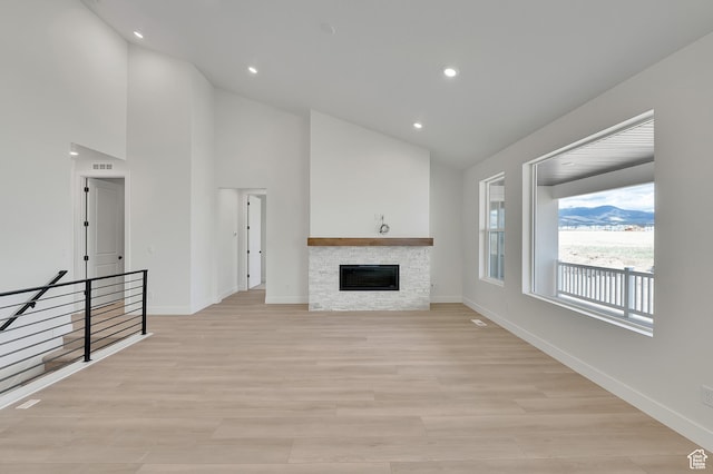 6184 W Teton Ranch Dr S Unit 304, Herriman, UT 84096 - unfurnished living room featuring baseboards, high vaulted ceiling, light wood finished floors, a fireplace, and recessed lighting