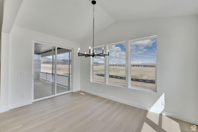 6184 W Teton Ranch Dr S Unit 304, Herriman, UT 84096 - unfurnished dining area featuring a chandelier, wood finished floors, vaulted ceiling, and baseboards