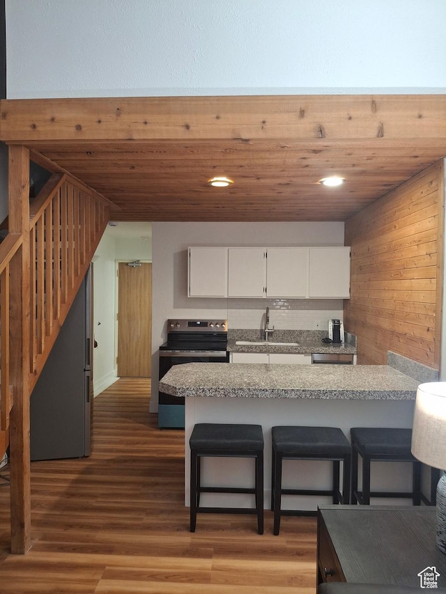 2255 Sidewinder Dr Unit 621, Park City, UT 84060 - kitchen featuring sink, a breakfast bar area, wood-type flooring, white cabinets, and kitchen peninsula
