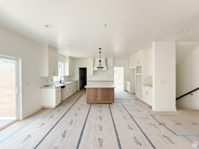 5330 N Springview Ct Unit 105, Lehi, UT 84043 - kitchen featuring a center island, plenty of natural light, white cabinetry, a textured ceiling, and recessed lighting
