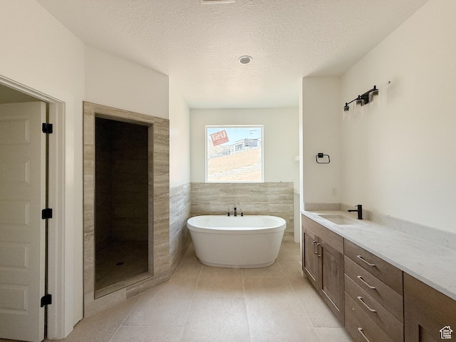 5330 N Springview Ct Unit 105, Lehi, UT 84043 - full bathroom featuring a soaking tub, vanity, a textured ceiling, tile patterned floors, and a wainscoted wall