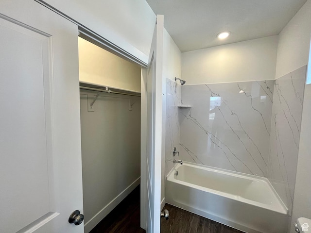 full bathroom with wood finished floors, shower / bathing tub combination, and a walk in closet