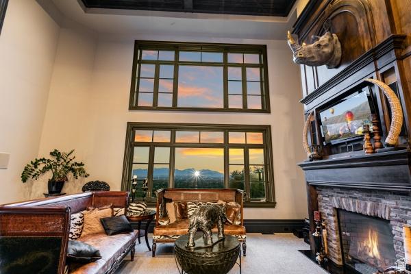 living area with a fireplace, light colored carpet, and a high ceiling