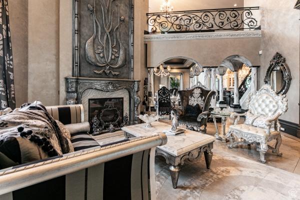 living room featuring a towering ceiling, a premium fireplace, and a notable chandelier