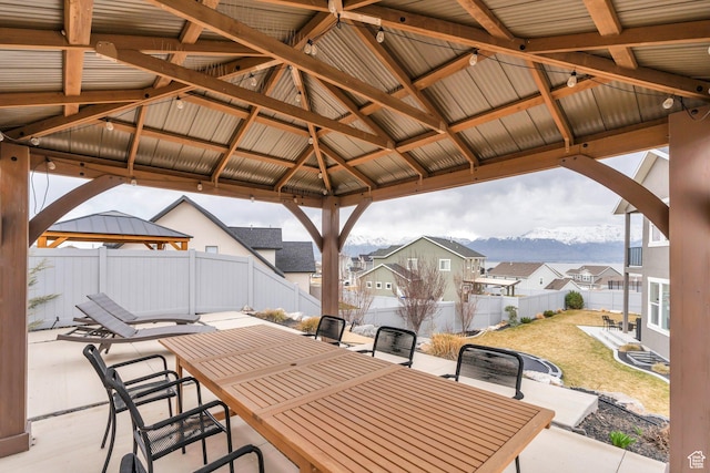 668 W Leroy Cir, Saratoga Springs, UT 84045 - view of patio / terrace featuring a fenced backyard, outdoor dining space, a gazebo, a residential view, and a mountain view