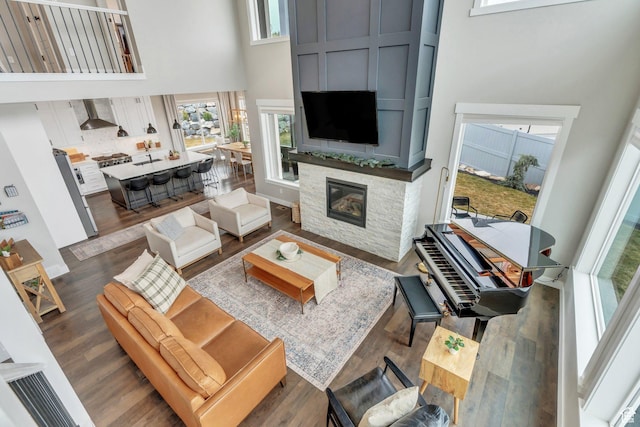 668 W Leroy Cir, Saratoga Springs, UT 84045 - living room featuring a high ceiling, a fireplace, and dark wood finished floors