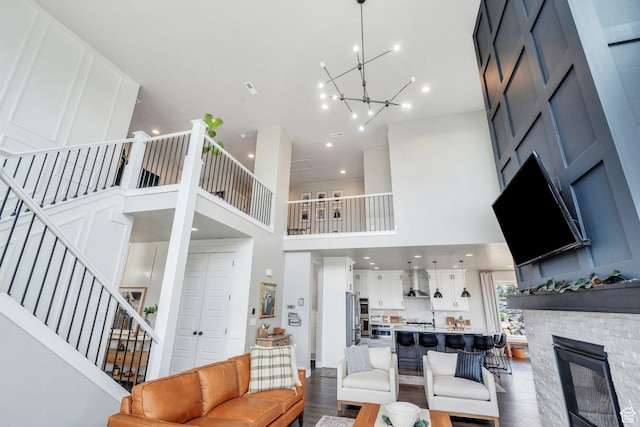 668 W Leroy Cir, Saratoga Springs, UT 84045 - living area with a notable chandelier, stairway, a fireplace, a high ceiling, and wood finished floors
