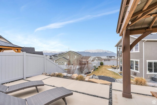 668 W Leroy Cir, Saratoga Springs, UT 84045 - view of patio / terrace featuring central air condition unit, a mountain view, and a fenced backyard
