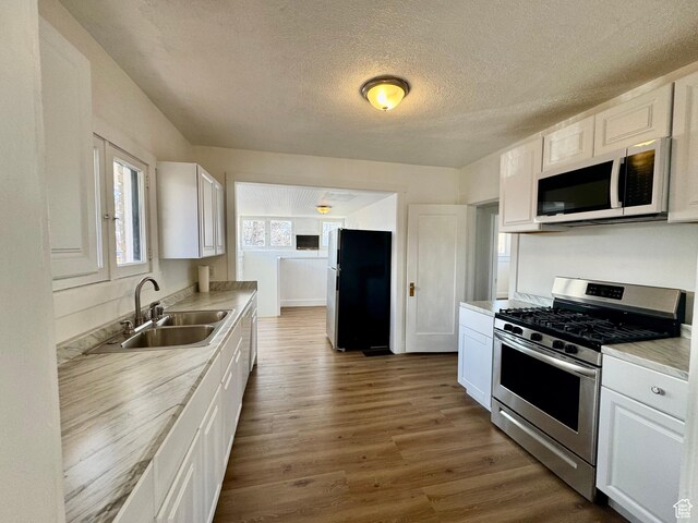 2721 Gramercy Ave, Ogden, UT 84403 - kitchen featuring a sink, appliances with stainless steel finishes, dark wood finished floors, and white cabinetry