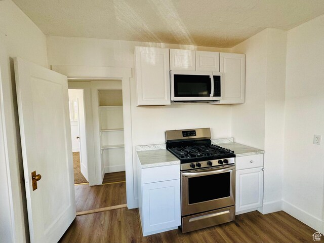2721 Gramercy Ave, Ogden, UT 84403 - kitchen featuring white microwave, gas range, white cabinetry, and light countertops