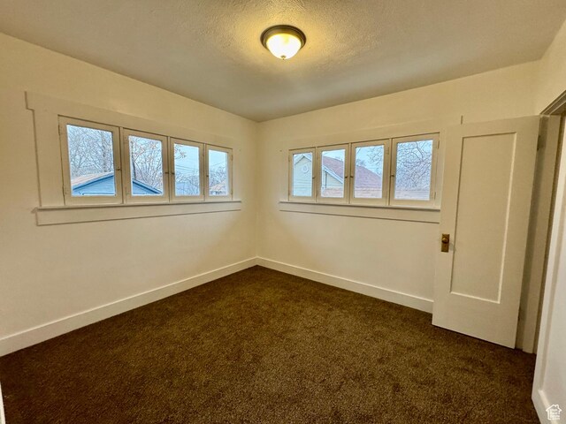 2721 Gramercy Ave, Ogden, UT 84403 - unfurnished room featuring a textured ceiling, baseboards, and dark colored carpet
