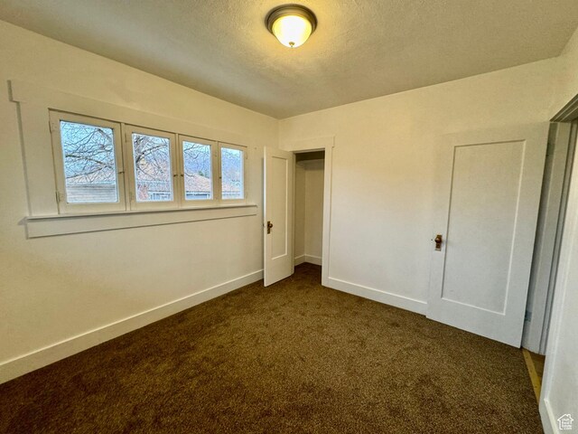 2721 Gramercy Ave, Ogden, UT 84403 - unfurnished bedroom featuring baseboards, a textured ceiling, and dark carpet