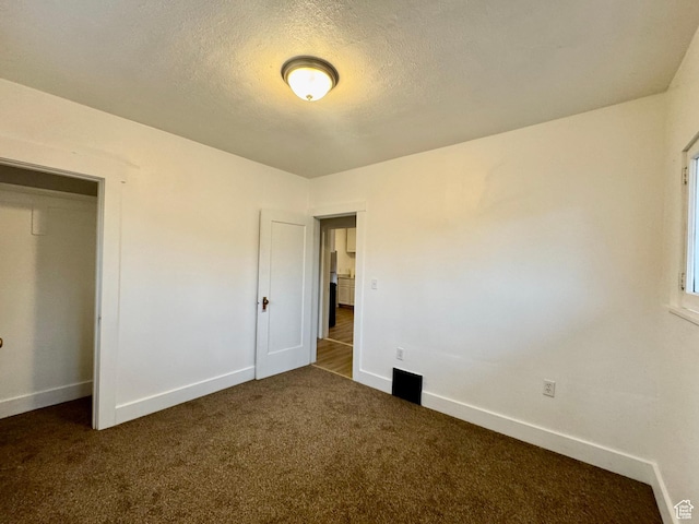 2721 Gramercy Ave, Ogden, UT 84403 - unfurnished bedroom with dark colored carpet, baseboards, and a textured ceiling