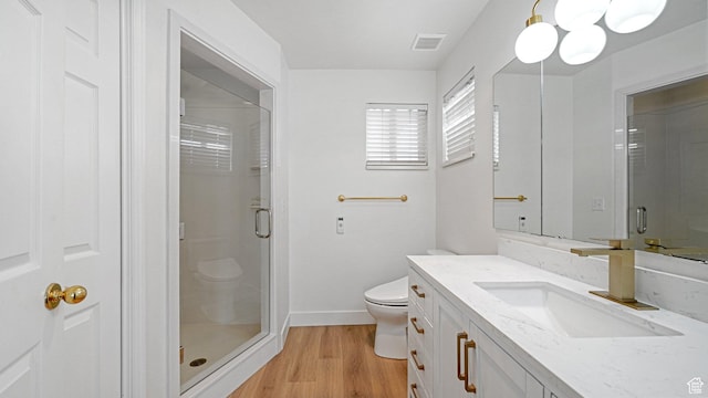 bathroom featuring walk in shower, vanity, toilet, and hardwood / wood-style flooring