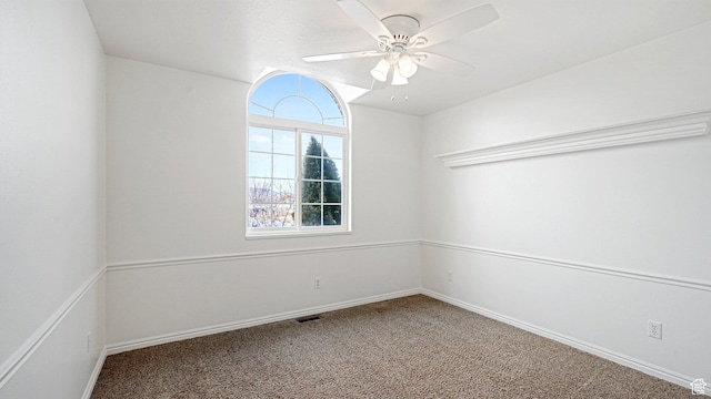 carpeted spare room featuring ceiling fan