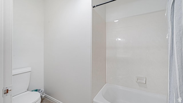 bathroom with tub / shower combination and toilet