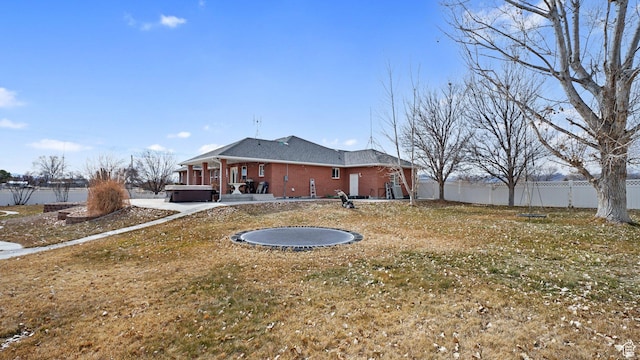 view of yard featuring a trampoline and a hot tub