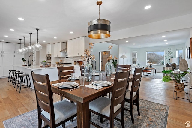dining space with recessed lighting and light wood finished floors