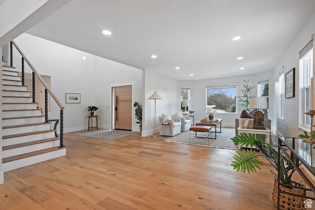 foyer with recessed lighting, baseboards, stairway, and light wood finished floors