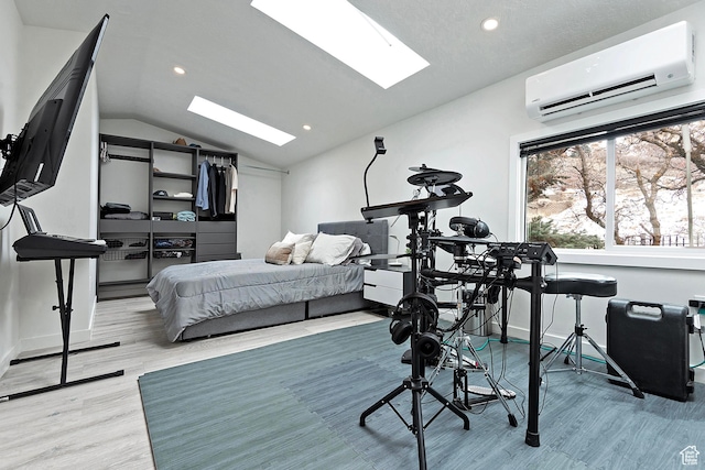 bedroom featuring light wood-style floors, recessed lighting, an AC wall unit, and lofted ceiling with skylight