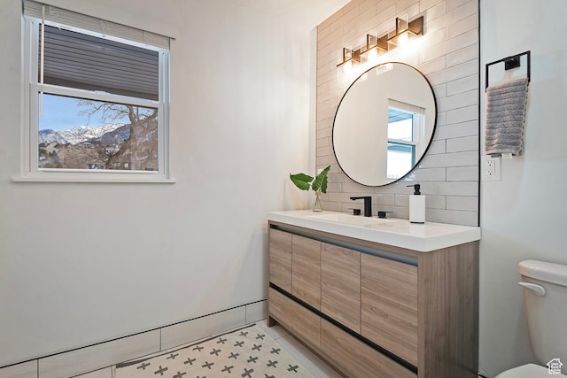 bathroom with vanity, decorative backsplash, tile patterned floors, and toilet