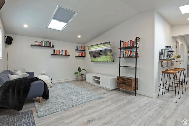 living room with recessed lighting, baseboards, wood finished floors, and vaulted ceiling with skylight