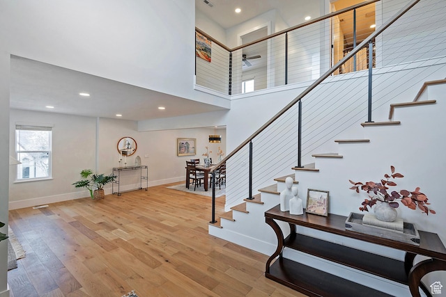 staircase with baseboards, recessed lighting, ceiling fan, and wood finished floors