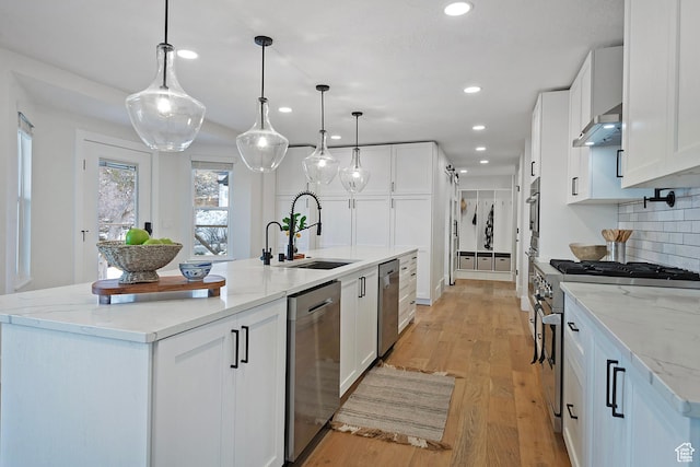 kitchen with decorative backsplash, recessed lighting, white cabinetry, a sink, and appliances with stainless steel finishes