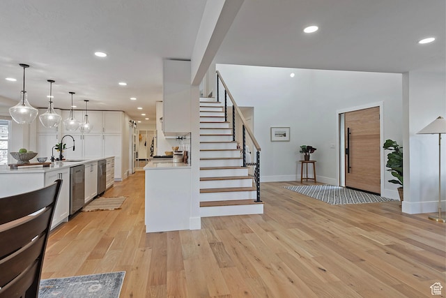 kitchen featuring dishwasher, light countertops, baseboards, white cabinets, and recessed lighting