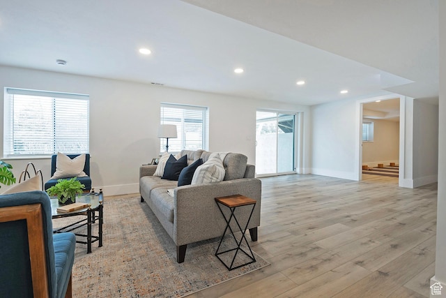 living room with recessed lighting, baseboards, visible vents, and light wood finished floors
