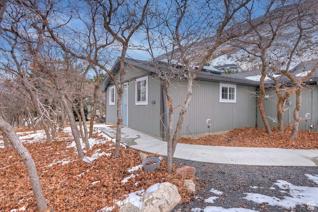 view of snowy exterior with roof with shingles