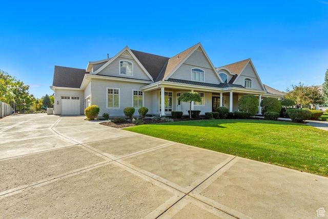 view of front of house with a porch, a garage, and a front lawn