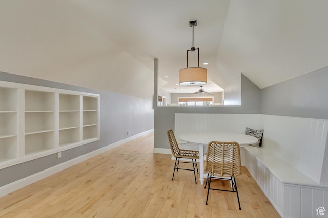 living area featuring built in shelves, lofted ceiling, light hardwood / wood-style flooring, and breakfast area