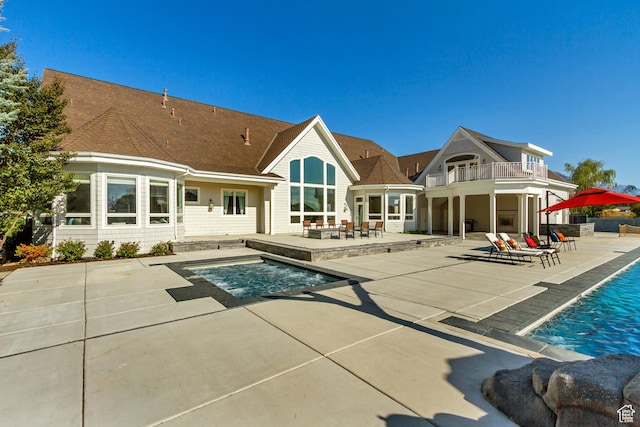 back of house with a balcony and a patio