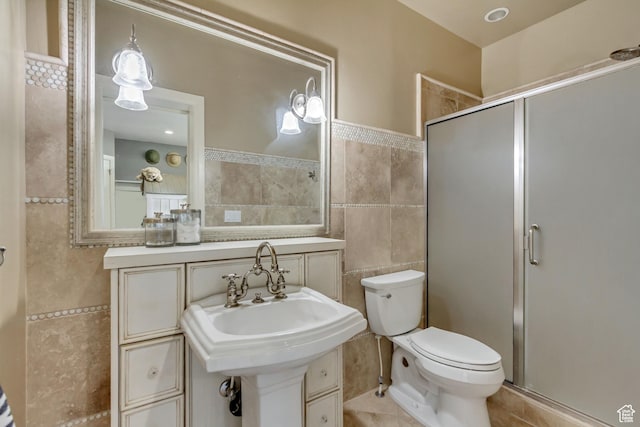 bathroom with sink, tile walls, tile patterned flooring, walk in shower, and toilet