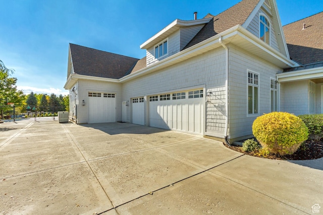 view of property exterior with cooling unit and a garage