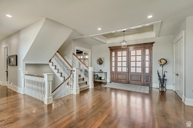 entryway featuring french doors, ornamental molding, dark hardwood / wood-style flooring, and a raised ceiling