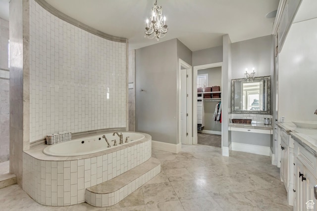bathroom featuring vanity, tiled bath, and a notable chandelier