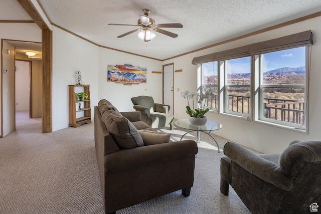 living room featuring ceiling fan, light colored carpet, ornamental molding, and a textured ceiling