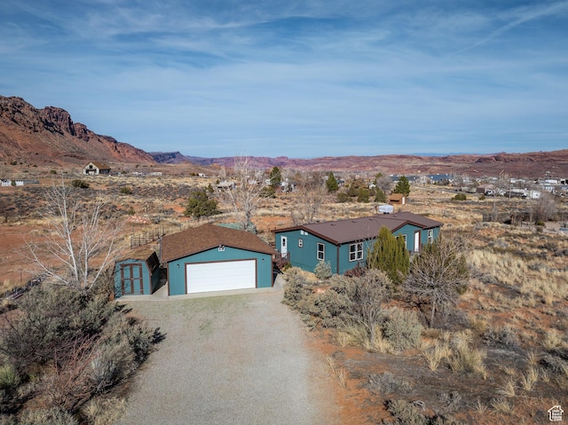 view of front of house featuring a storage shed, a garage, and a mountain view